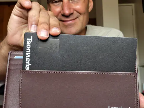 Un homme montre une carte Lenvorat dans son portefeuille